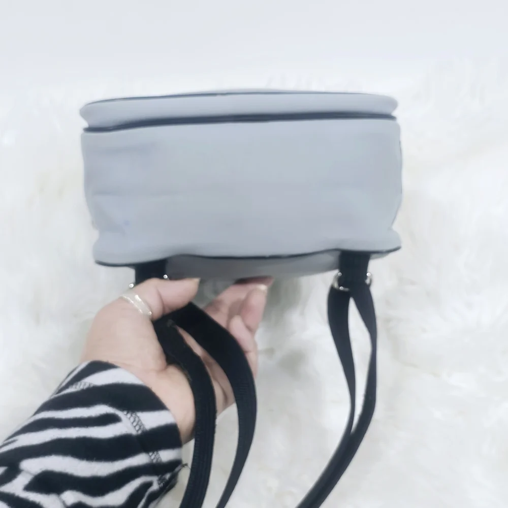Lacoste mini backpack in a soft light blue shade with navy blue trim accents.